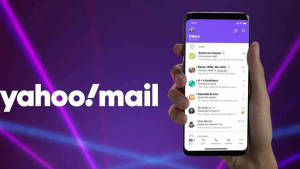 手拿著顯示 Yahoo Mail 應用程式的智能手機，背景是發光的紫色霓虹燈。