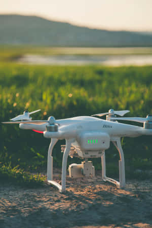 日落時草地上帶有綠色燈光的白色無人機 — 小米Pad 9 Pro 壁紙