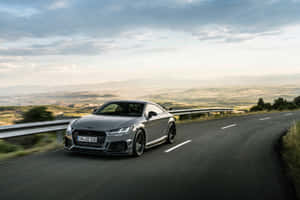 銀色奧迪TT RS在日落時分於山路上飛馳。 — Audi R8 GIF 壁紙