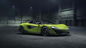 在昏暗的工業倉庫中，聚光燈下的青檸綠色McLaren跑車。 — 4K 法拉利 壁紙