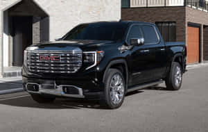 黑色GMC Sierra Denali皮卡車停在現代建築附近的街道上。 — Steam Deck 壁紙