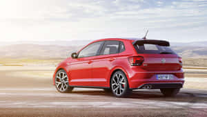 紅色福士 Polo GTI 在沙漠賽道上，背景有山丘。 — 奧迪 GIF 壁紙