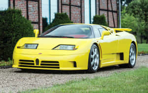 黃色Bugatti EB110超級跑車停泊在磚砌建築附近的碎石地上。 — MacBook Pro 13 壁紙