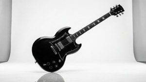 黑色Gibson電結他放在反射性白色錄音室地板上