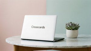 白色手提電腦帶有 Crosscards 標誌，放在大理石桌上，旁邊有一盆多肉植物。