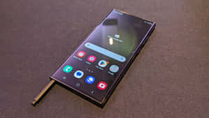 黑色智能手機連觸控筆在深色紋理表面上 — Samsung S23 Ultra 壁紙