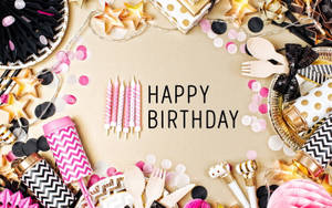 生日派對用品圍繞米色表面上寫有「HAPPY BIRTHDAY」的文字排列。