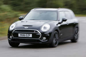 黑色MINI Countryman S在道路上行駛，帶有動態模糊效果。 — Surface Pro 壁紙