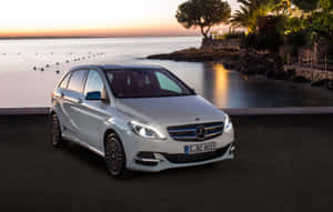 日落時分停泊在海邊的白色 Mercedes-Benz B-Class 電動車。 — Steam Deck OLED 壁紙
