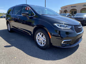 黑色Chrysler Pacifica小型貨車停放在陽光明媚的經銷商停車場。