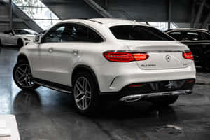白色 Mercedes-Benz GLE 350d Coupe 在汽車展廳內，地板拋光。 — Surface Pro 壁紙