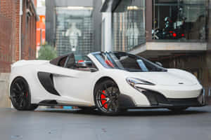 白色McLaren跑車停在城市行人道上，靠近磚砌建築。 — MacBook Air M3 壁紙