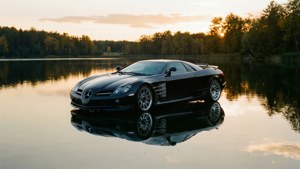 黑色 Mercedes SLR McLaren 在平靜的湖面上映照日落