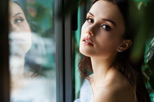 女人望向窗外，倒影模糊
