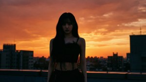 日落時分屋頂上女人的剪影，俯瞰城市