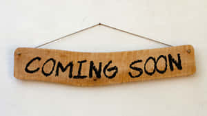 寫着「COMING SOON」的木牌掛在白色牆上。