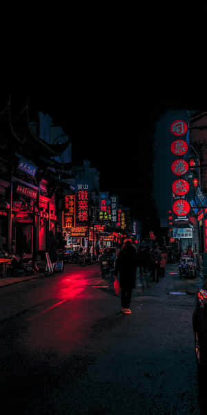 一個人在夜晚走在一條霓虹燈照亮的後巷，潮濕的路面上有紅色倒影。 — 夜景城市 壁紙