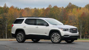 白色GMC Acadia SUV停在色彩繽紛的秋樹前。 — 16:9 壁紙