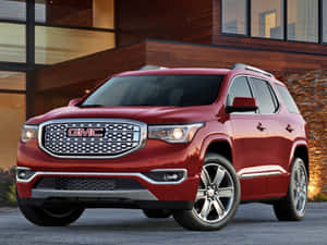 紅色GMC Acadia SUV停在一間帶有木質牆板和大型窗戶的現代住宅前。 — 4:3 壁紙