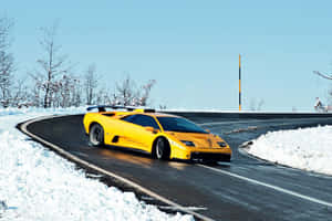 黃色林寶堅尼 Murciélago 在積雪的山路上飛馳。 — Surface Pro 壁紙