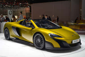 黃色McLaren 675LT Spider在車展上展出，背景有人群。 — MacBook Air M2 壁紙