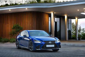 藍色Lexus LS 500 F Sport在黃昏時停在現代木屋前。 — MacBook Pro M4 壁紙