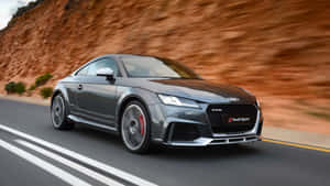 灰色奧迪TT RS在橙色懸崖旁的道路上疾馳。 — Audi R8 GIF 壁紙