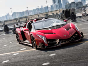天台上的紅色林寶堅尼 Veneno Roadster，背後是城市天際線。 — 蘭博基尼 壁紙