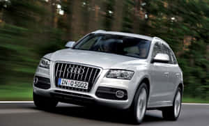 銀色 Audi Q5 SUV 在森林中的道路上行駛。 — 奧迪 GIF 壁紙