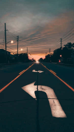 暮色街道，有車頭燈和人行道的方向箭頭