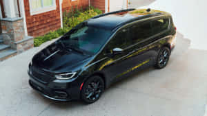 黑色小型貨車帶金色點綴停在房子前面。