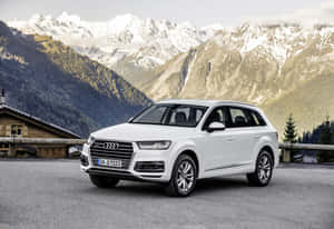 白色奧迪Q7 SUV停泊在山間木屋附近，背後是白雪覆蓋的山峰。 — Audi R8 GIF 壁紙