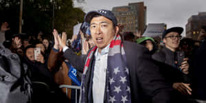 政治家在晚間集會上戴著美國國旗圍巾和競選標語向支持者揮手。 — 政治 壁紙