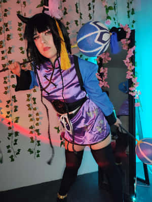 穿著紫色和藍色動漫服裝、帶有角和蝴蝶圖案的cosplayer，手持發光球體擺姿勢。 — iPad Pro 13 壁紙