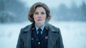 一位穿著軍裝的女性在冬季站在雪地上。