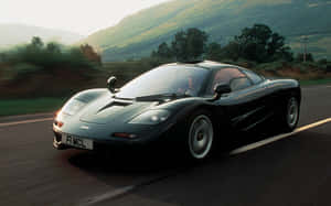 日落時分黑色McLaren F1在山路上飛馳 — Steam Deck 壁紙
