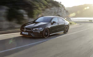 黑色Mercedes-AMG CLA 35 S E Performance在日落時分於海岸道路飛馳 — Steam Deck OLED 壁紙