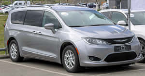 銀色 Chrysler Pacifica 小型貨車停泊在公共停車場。