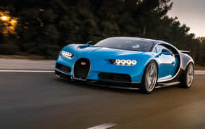 一輛藍色Bugatti Chiron在日落時分在道路上疾馳，背景有樹木。 — Steam Deck OLED 壁紙