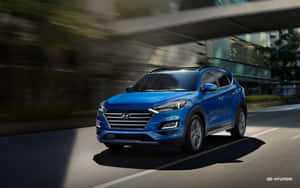 藍色現代 Tucson SUV 在模糊背景的城市街道上快速行駛。 — Steam Deck 壁紙