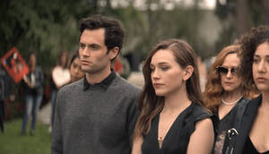 一群人在日落時分的公園裡莊嚴地站立。 — Netflix GIF 壁紙