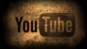 粗糙混凝土牆上的 YouTube 標誌，帶有聚光燈和暗邊。 — 音樂 GIF 壁紙