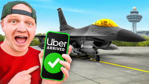 男子在機場戰鬥機旁興奮地展示手機上的Uber應用程式。