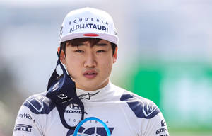 賽車手穿著Scuderia AlphaTauri裝備拿著頭盔面罩