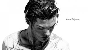 Zac Efron 的黑白工作室肖像，濕髮，向下凝視。
