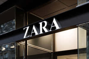 ZARA商店入口，帶有發光標誌和玻璃窗，夜晚。