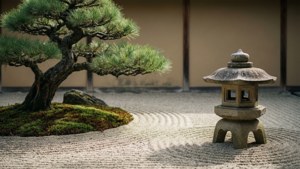 在耙平的礫石禪意花園中的石燈籠和盆景樹