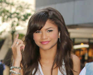 Zendaya 微笑，長棕色頭髮，手指舉起 — 善逸 GIF 壁紙
