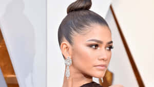 Zendaya 在正式活動中戴著華麗的鑽石耳環和高髻。