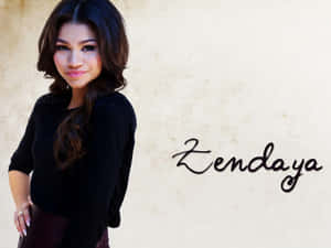 Zendaya 穿著黑色上衣，在有紋理的米色牆前微笑，旁邊寫著她的名字。 — 善逸 GIF 壁紙